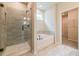 Modern bathroom featuring a glass-enclosed shower, soaking tub, and neutral tile at 142 Henley St, Canton, GA 30114