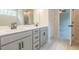 Bright bathroom with a double vanity, tile floor, and access to bedroom with ceiling fan at 142 Henley St, Canton, GA 30114
