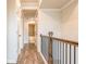 Upstairs hallway with hardwood floors, white trim, and wood railing at 142 Henley St, Canton, GA 30114