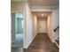 Hallway with hardwood floors leading to an open door and a carpeted room at 142 Henley St, Canton, GA 30114