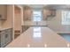 Bright kitchen boasts grey cabinets, stainless steel appliances, and an expansive quartz island at 142 Henley St, Canton, GA 30114