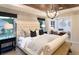 Luxurious bedroom with a tufted headboard, wood ceiling, stylish lighting, and large windows providing lots of natural light at 264 Rockledge Sw Bnd, Powder Springs, GA 30127