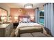 Charming pink bedroom with stylish decor, a comfortable bed, and a bright window at 264 Rockledge Sw Bnd, Powder Springs, GA 30127