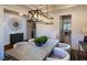 A dining room with a wood table, white chairs, modern chandelier, and an accent mirror at 264 Rockledge Sw Bnd, Powder Springs, GA 30127