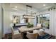 A dining room featuring a wood table, white chairs, modern light fixture, and large picture window at 264 Rockledge Sw Bnd, Powder Springs, GA 30127