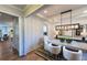 A dining room featuring a modern light fixture, white chairs, a textured rug, and decorative artwork at 264 Rockledge Sw Bnd, Powder Springs, GA 30127