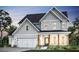 Charming two-story home featuring a light gray exterior, gabled roof, covered porch, and a two-car garage at 264 Rockledge Sw Bnd, Powder Springs, GA 30127