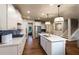 Spacious white kitchen with stainless steel appliances, large island, and modern lighting fixtures at 264 Rockledge Sw Bnd, Powder Springs, GA 30127