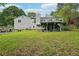 Exterior view showcasing a spacious backyard with a deck, well-manicured lawn, and mature trees at 3087 Sanibel Sw Dr, Stone Mountain, GA 30087