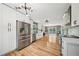 Open kitchen and living area with stainless appliances, modern lighting, and hardwood floors at 3087 Sanibel Sw Dr, Stone Mountain, GA 30087