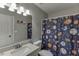 Fun bathroom features a sports-themed shower curtain, modern vanity, and ample lighting at 6606 Wellington Sq, Norcross, GA 30093