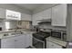 Well-lit kitchen featuring modern stainless steel appliances, white cabinets, and granite countertops at 6606 Wellington Sq, Norcross, GA 30093