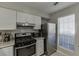 Well-lit kitchen featuring modern stainless steel appliances, white cabinets, and granite countertops at 6606 Wellington Sq, Norcross, GA 30093