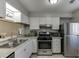 Well-lit kitchen featuring modern stainless steel appliances, white cabinets, and granite countertops at 6606 Wellington Sq, Norcross, GA 30093