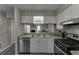 Well-lit kitchen featuring modern stainless steel appliances, white cabinets, and granite countertops at 6606 Wellington Sq, Norcross, GA 30093