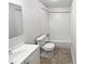 Clean bathroom featuring a vanity, toilet, and shower-tub combination with white tiling at 3103 Mote Rd, Covington, GA 30016