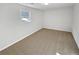 Cozy bedroom featuring neutral carpeting, a window overlooking the yard, and freshly painted white walls at 3103 Mote Rd, Covington, GA 30016