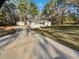 A well-manicured lawn and driveway lead up to a charming one-story home surrounded by mature trees at 3103 Mote Rd, Covington, GA 30016