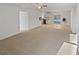 Open-concept living area featuring plush carpeting, modern lighting, and sliding glass doors to the yard at 3103 Mote Rd, Covington, GA 30016