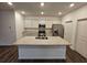 Bright kitchen showcases a large central island with a sink, stainless steel appliances, and wood-look flooring at 656 Friesland Dr, Hampton, GA 30228