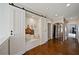 Bright hallway features hardwood floors, sliding barn doors and a built-in bench with storage at 7165 Cordery Rd, Cumming, GA 30040