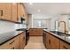 Open modern kitchen featuring dark countertops and light wood cabinets at 148 Henley St, Canton, GA 30114