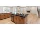 Kitchen island featuring a stainless steel sink, black countertop, and wooden cabinets at 148 Henley St, Canton, GA 30114