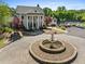 Elegant clubhouse entrance with a circular driveway, fountain, and manicured landscaping at 23 Knollwood Nw Way, Cartersville, GA 30121