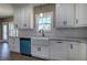 Modern white kitchen with granite countertops, a white farmhouse sink, and stainless steel appliances at 30 Grand Georgian Ne Ct, Cartersville, GA 30121