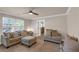 Cozy living room featuring comfortable sofas, an ottoman, and natural light from a large window at 4869 Locherby Dr, Fairburn, GA 30213