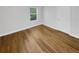 Clean, minimalist bedroom featuring hardwood floors, a window, and a door at 1950 S Inlet, Marietta, GA 30066