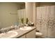 Well-lit bathroom featuring double sinks and a decorative shower curtain at 2268 Redfern Rd, Dacula, GA 30019