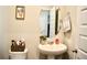 Updated bathroom with oval mirror, pedestal sink, toilet and neutral wall color at 2268 Redfern Rd, Dacula, GA 30019