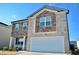 Charming two-story home with stone and brick exterior, a manicured lawn, and a two-car garage at 2268 Redfern Rd, Dacula, GA 30019