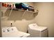 A bright laundry room with newer white front-loading machines, and storage shelf with towels and laundry supplies at 2268 Redfern Rd, Dacula, GA 30019