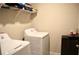 Clean laundry area features white machines, upper shelving for supplies, and a black compact refrigerator at 2268 Redfern Rd, Dacula, GA 30019