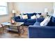 Comfortable living room featuring stylish blue sofas, a glass coffee table, and wood floors at 2268 Redfern Rd, Dacula, GA 30019