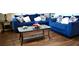 Comfortable living room featuring stylish blue sofas, a glass coffee table, and wood floors at 2268 Redfern Rd, Dacula, GA 30019