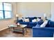 Comfortable living room featuring stylish blue sofas, a glass coffee table, and wood floors at 2268 Redfern Rd, Dacula, GA 30019