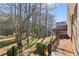 Multi-level wooden deck overlooking a spacious backyard with mature trees and lush greenery, perfect for outdoor living at 3540 Honeycomb Se Dr, Conyers, GA 30094
