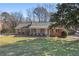 Charming brick ranch home with a well-manicured front yard, mature trees, and a cozy front porch at 3540 Honeycomb Se Dr, Conyers, GA 30094