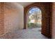 Arched brick entrance featuring a brick floor and views of the home's well-manicured front yard at 1245 Village Terrace Ct, Dunwoody, GA 30338