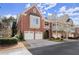 Beautiful brick home showcasing an attached two-car garage and well-manicured landscaping at 1245 Village Terrace Ct, Dunwoody, GA 30338