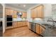 Modern kitchen with stainless steel appliances and fixtures, granite countertops, and hardwood floors at 1245 Village Terrace Ct, Dunwoody, GA 30338