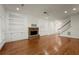 Open-concept living room featuring hardwood floors, built-in cabinetry, and a stone fireplace at 1245 Village Terrace Ct, Dunwoody, GA 30338