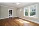 Sun-drenched bedroom with gleaming hardwood floors, neutral walls, and large windows overlooking lush greenery at 1709 Rogers Sw Ave, Atlanta, GA 30310