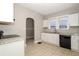 Well-lit kitchen showcasing white cabinets, granite countertops, black appliances, and tile flooring at 1709 Rogers Sw Ave, Atlanta, GA 30310