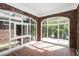 Bright sunroom with brick walls, red tiled floor, and multiple windows offering scenic outdoor views at 1709 Rogers Sw Ave, Atlanta, GA 30310