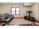 Finished basement space with plush carpeting, a window with blinds, and a brown leather sofa with a cup holder at 1755 Presidents Dr, Lawrenceville, GA 30043