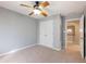 Neutral-toned bedroom featuring a ceiling fan, double closet doors, and an open doorway to the hallway at 1755 Presidents Dr, Lawrenceville, GA 30043